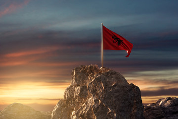 Wehende albanische Fahne auf Bergspitze im wunderschönen Abendrot