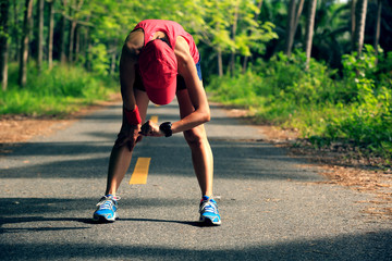 Young fitness woman runner have a rest checking the sports watch