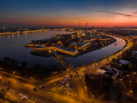 Russia, Saint-Petersburg, 02 November 2017: Aerial photo of Peter and Paul Fortress at sunset, cathedral, traffic, nightlights, illumination, clear weather, reflections, cityscape, landmark, Hermitage