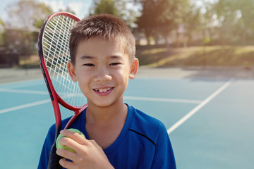 Young tween multiethnic Asian boy tennis player on outdoor blue court, preteen sport, kid active fitness