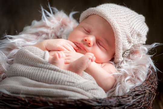 Cute newborn baby sleeping in the basket with blanket