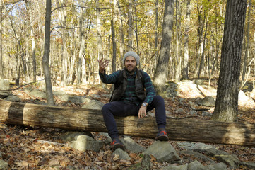 Fototapeta premium Man is sitting in autumn forest in the mountains. Hiking and traveling