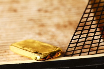 Gold bar put on the floor of miniature ship model scene.