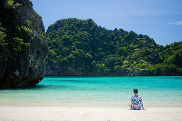  Young woman sitting on beach.travel on holidays. Girl enjoying at summer. relax on beach. Happy time