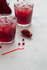 Pomegranat juice with ice and fruit slices, copy space