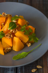 Salad with pumpkin, walnuts and green leaves