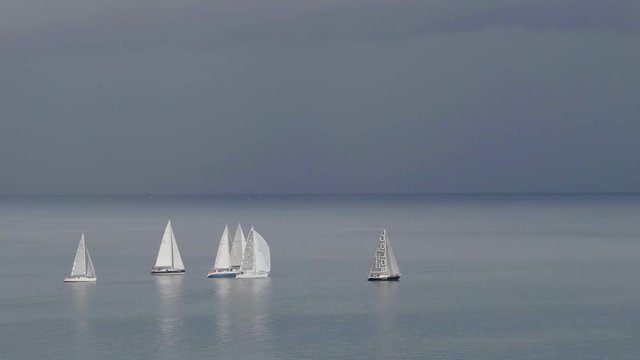 Sailboats in the Gulf of Venice as lightning strikes the water from a rain storm moving in on the Piran Coast in Slovenia.