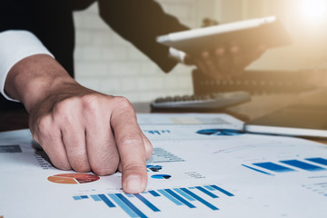 Business man working at office with laptop, tablet ,calculator and graph data documents   for  Plans to improve quality next month on his desk.