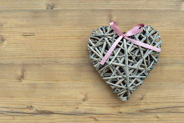 A heart made of straw on a wooden background