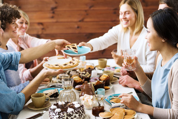 One of guests asking for slice of sweet pie during home celebration of holiday by festive table