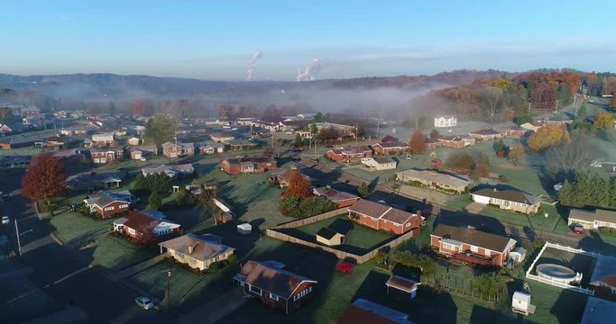A reverse aerial establishing shot of a typical Western Pennsylvania residential neighborhood on a frosty late-Autumn morning. Pittsburgh suburbs. Shot at 60fps.  	