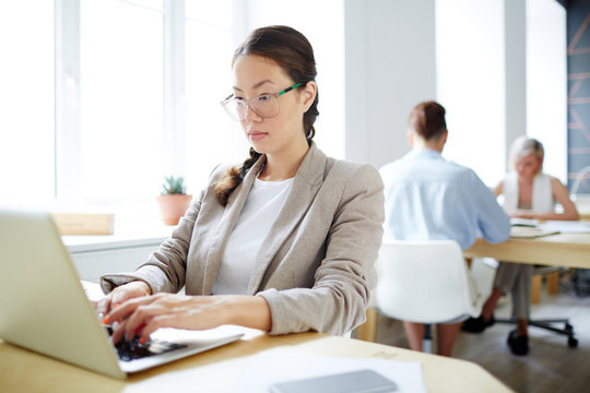 Young employee concentrating on reading online data and analyzing it
