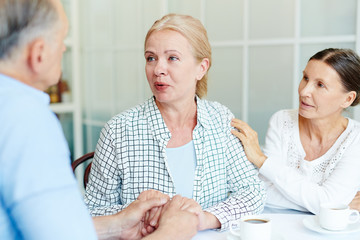 Obraz premium Helpful friends expressing sympathy towards problems of mature woman sharing her fears with them