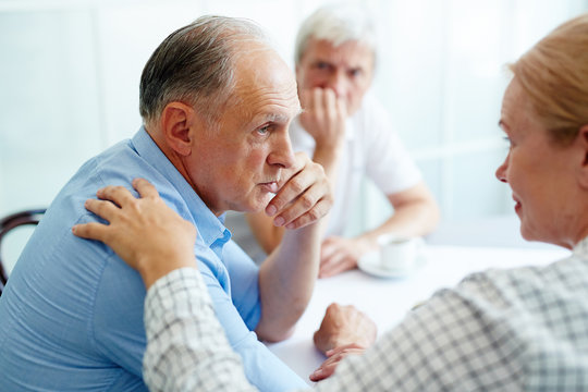 Senior man sharing his trouble with understanding friends who care