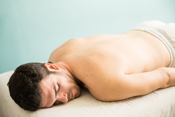 Obraz na płótnie Canvas Man lying on a massage bed