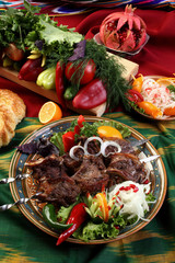 Kebab of lamb fillet marinated in wine vinegar.Ground black and red pepper,coriander seeds,salt to taste.Sola served with vegetables and lemon.Uzbek cuisine.The upper projection.
