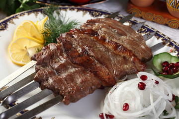 Kebab Besh-Panja.Large slices of mutton and sheep's tail fat strung on five skewers.Salt,cumin,coriander seeds,ground black pepper to taste.To the table serve with onions and herbs.Uzbek cuisine