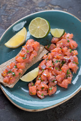 Turquoise plate with salmon tartare, close-up, vertical shot, selective focus