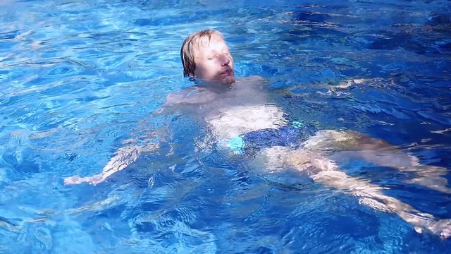 Man relaxing in swimming pool, slow motion. 1920x1080