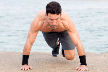 Athletic man with upper body free making push-ups exercise 