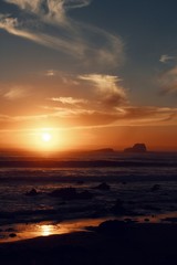 Fototapeta na wymiar sunset on the ocean skyline with clouds and island silhouette