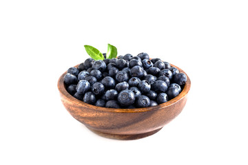 Juicy and fresh blueberries with green leaves on white bowl. Healthy eating