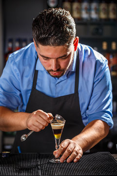Bartender preparing layered cocktail