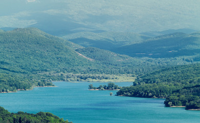 High mountains covered with forests over the lake