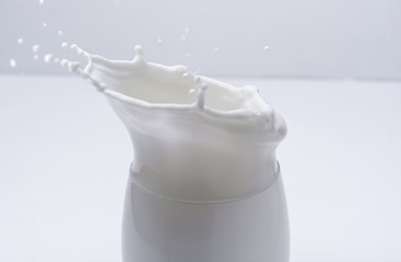 Splas de chocolate en vaso de leche con fondo blanco