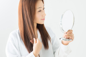 鏡で髪をチェックする女性
