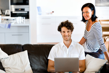 Couple at home using laptop