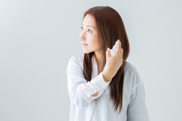 ヘアスプレーする女性
