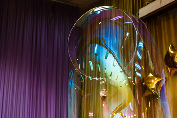Artist blowing many soap bubble from his hands bubble show