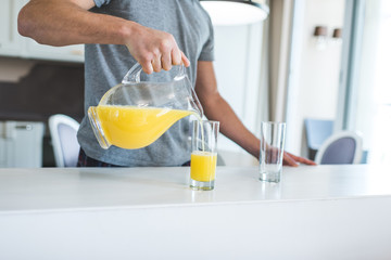 man pouring orange juice