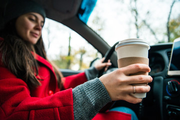 woman in car with cup of coffee