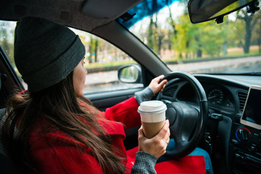 Woman In Car With Cup Of Coffee