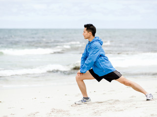 Young man doing exercise at the beach