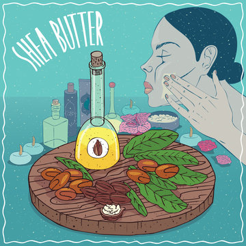 Glass Decanter of Shea butter oil and nuts of Vitellaria paradoxa plant. Girl applying facial mask on face. Natural vegetable oil used for skin care