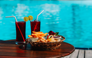 fish and chips with drinks served on tropical beach