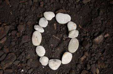 English alphabet (O - alphabet) from the white rock on the soil