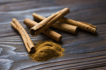 Cinnamon sticks and meal close up on wooden table