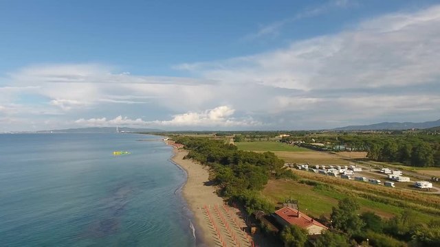 Coast of Tuscany in summer, aerial view of seaside and pinewood.