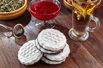 cookies with white chocolate frosting and raspberry jam in a little vase on the table for tea.