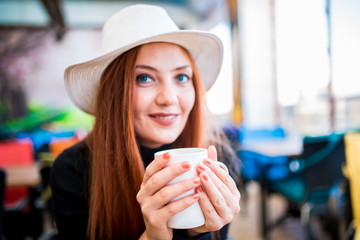 Beautiful girl drinking coffee at the coffee shop