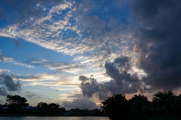 lakeside view of palm trees and orange fiery sunset