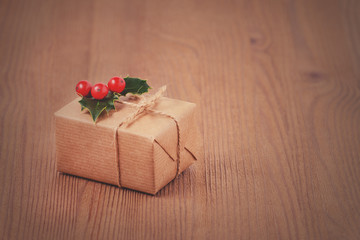 gift box all times with holly berries on wooden background, toned