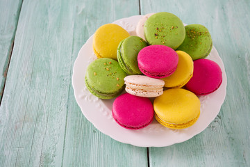 multicolored macaroons on turquoise wooden surface