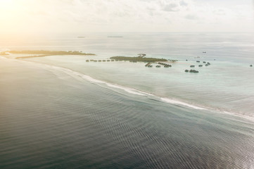 Tropical islands and atolls in Maldives in Indian Ocean from aerial view. Piece of paradise on the Earth. Good choice for vacation. Beautiful top view for wallpaper.