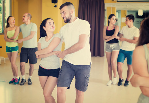 Enthusiastic dancing couples learning salsa