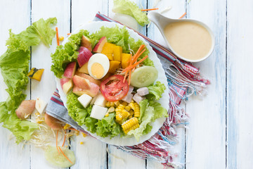Fresh Fruit and vegetable salad on white plate on wooden table